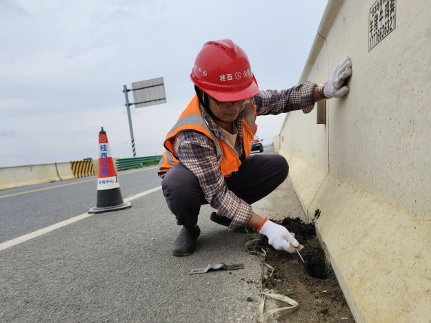 武鸣公路养护中心养护人员疏通桥梁泄水孔(陈莉莉摄).jpg